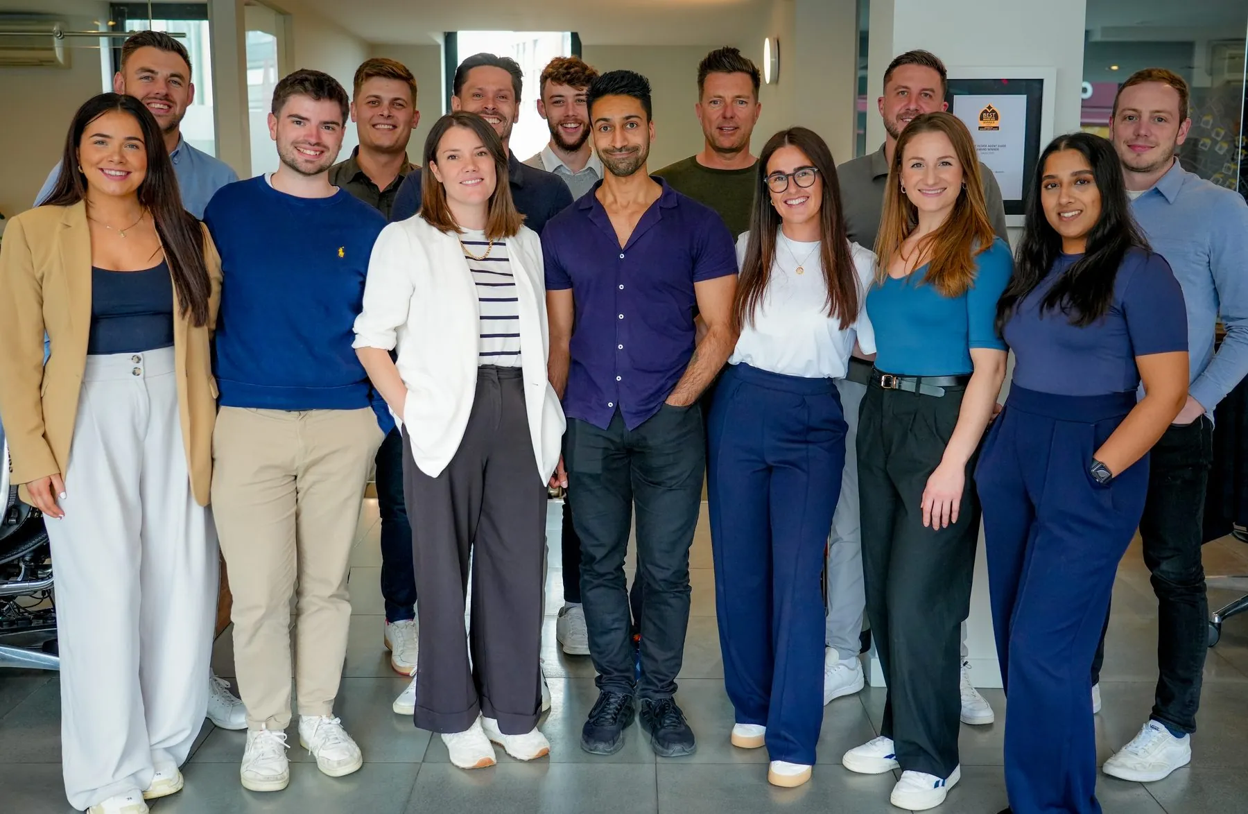 A large member agency team standing together in their own office