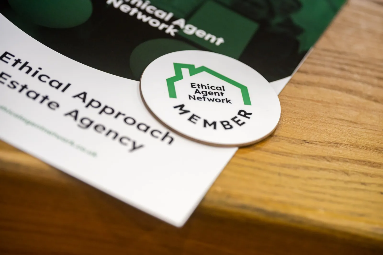 The Ethical Agent Network member badge resting on a member agency's own printed literature