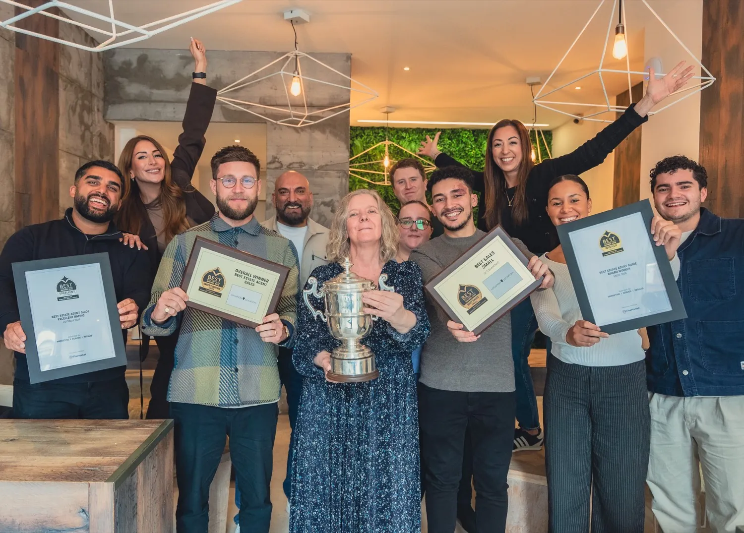 The team at an approved member agency holding their framed awards