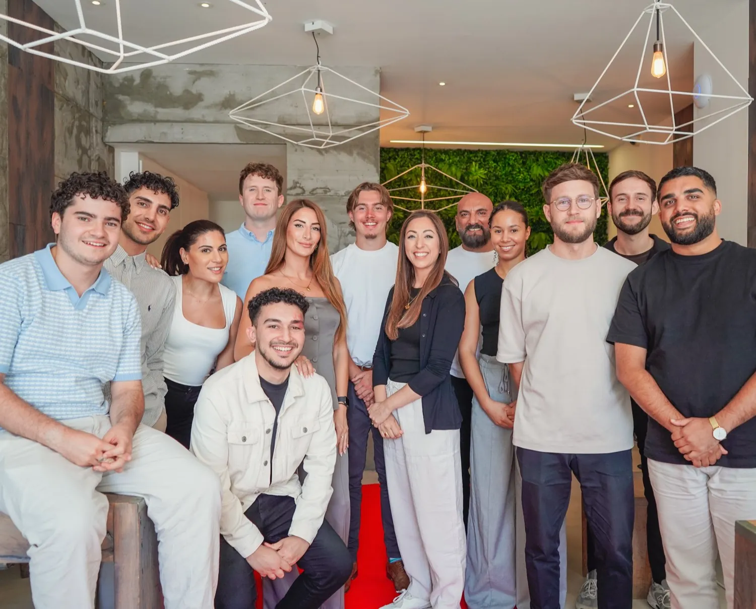A large member agency team together in their own office under pendant lights