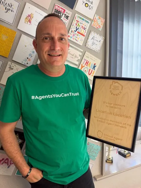 A member of Location Location, Thetford wearing the network's Agents You Can Trust shirt