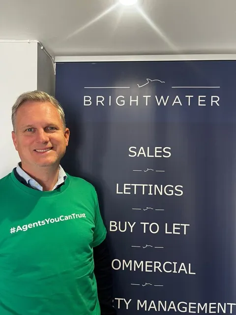 A member of Brightwater wearing the network's Agents You Can Trust shirt