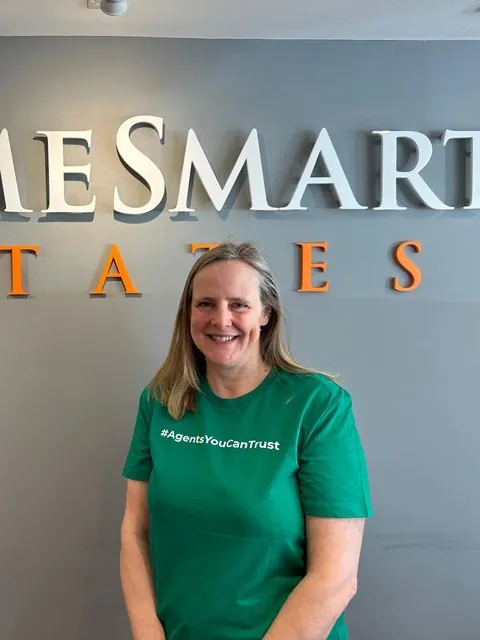 A member of HomeSmart Estates wearing the network's Agents You Can Trust shirt