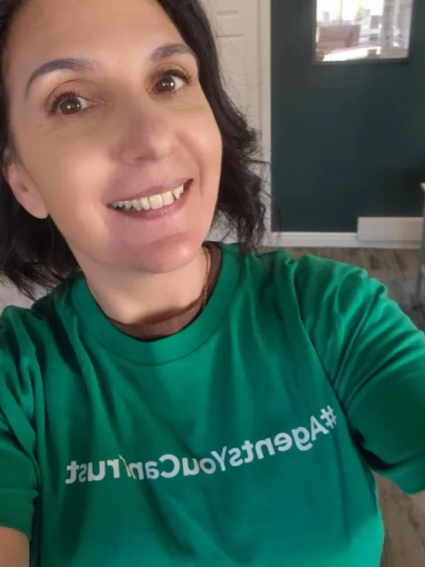 A member agency wearing the network's Agents You Can Trust shirt