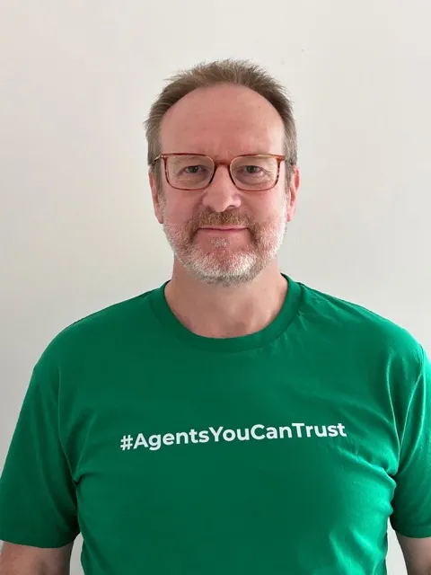 A member agency wearing the network's Agents You Can Trust shirt