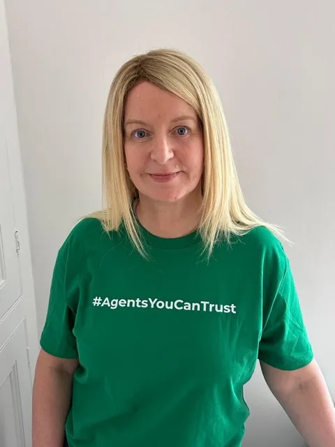 A member agency wearing the network's Agents You Can Trust shirt