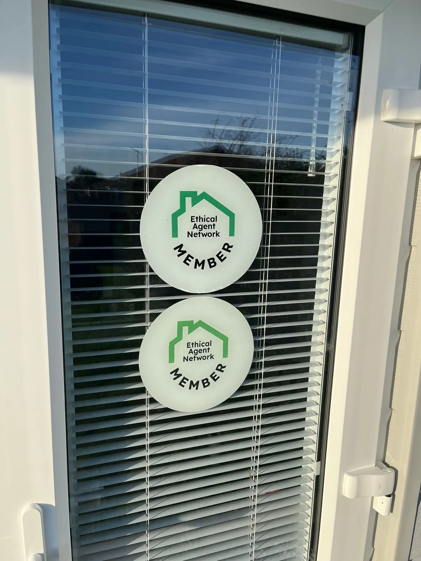 Two Ethical Agent Network member stickers on an agency door